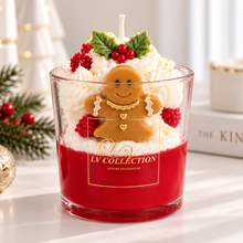 A festive Christmas-themed scented candle in a clear glass jar from LV Collection. The candle features a vibrant red wax base, topped with white whipped cream, green holly leaves, red berries, and a gingerbread man figure with gold details.