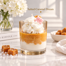 A layered dessert candle in a clear glass jar labeled LV COLLECTION, topped with whipped cream, caramel-colored wax, and a pink chocolate cube, styled on a light marble surface with caramel pieces, flowers, and a book in the background. Text reads 'Salted Caramel Dream'.