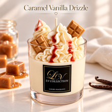 A glass jar candle topped with whipped cream, red drizzle, chocolate pieces, and vanilla beans, labeled LV COLLECTION, with caramel cubes and vanilla pods around it on a light surface.